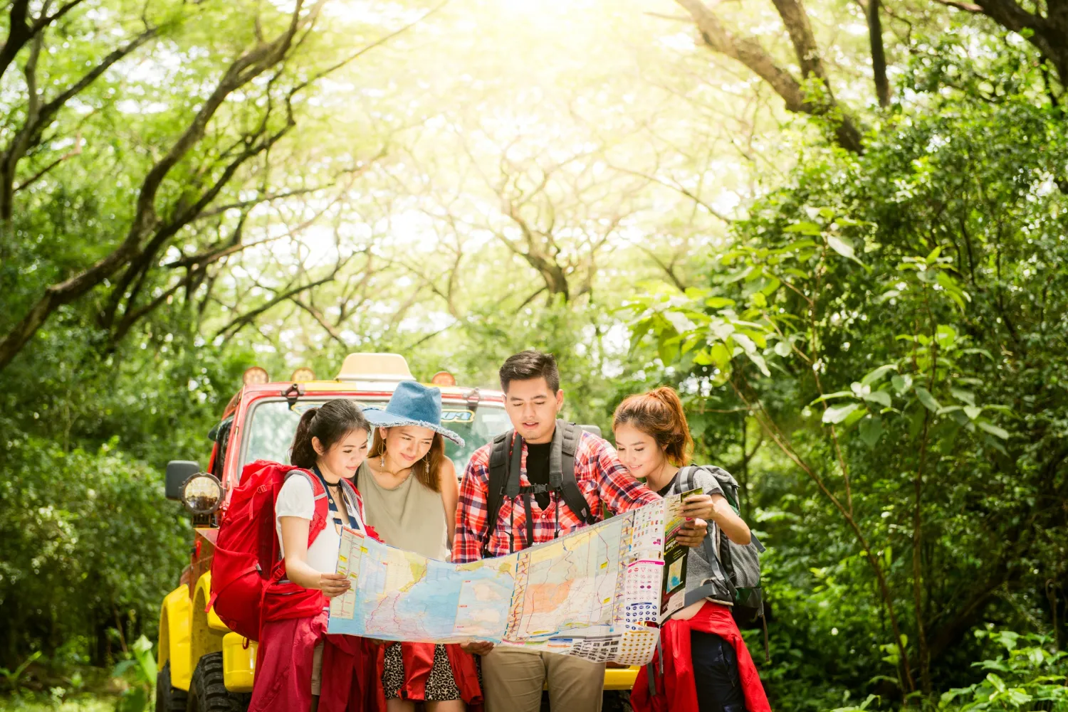 Couple or friends navigating together smiling happy during camping travel hike outdoors in forest